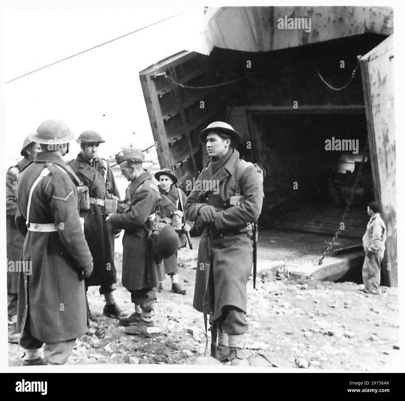 Verstärkung des Queens-Regiments, einschließlich des privaten Johnson, Wanderung zum Anzio Brückenkopfverstärkungslager und Rücksprache mit einem Militärpolizisten am Hafen. Stockfoto