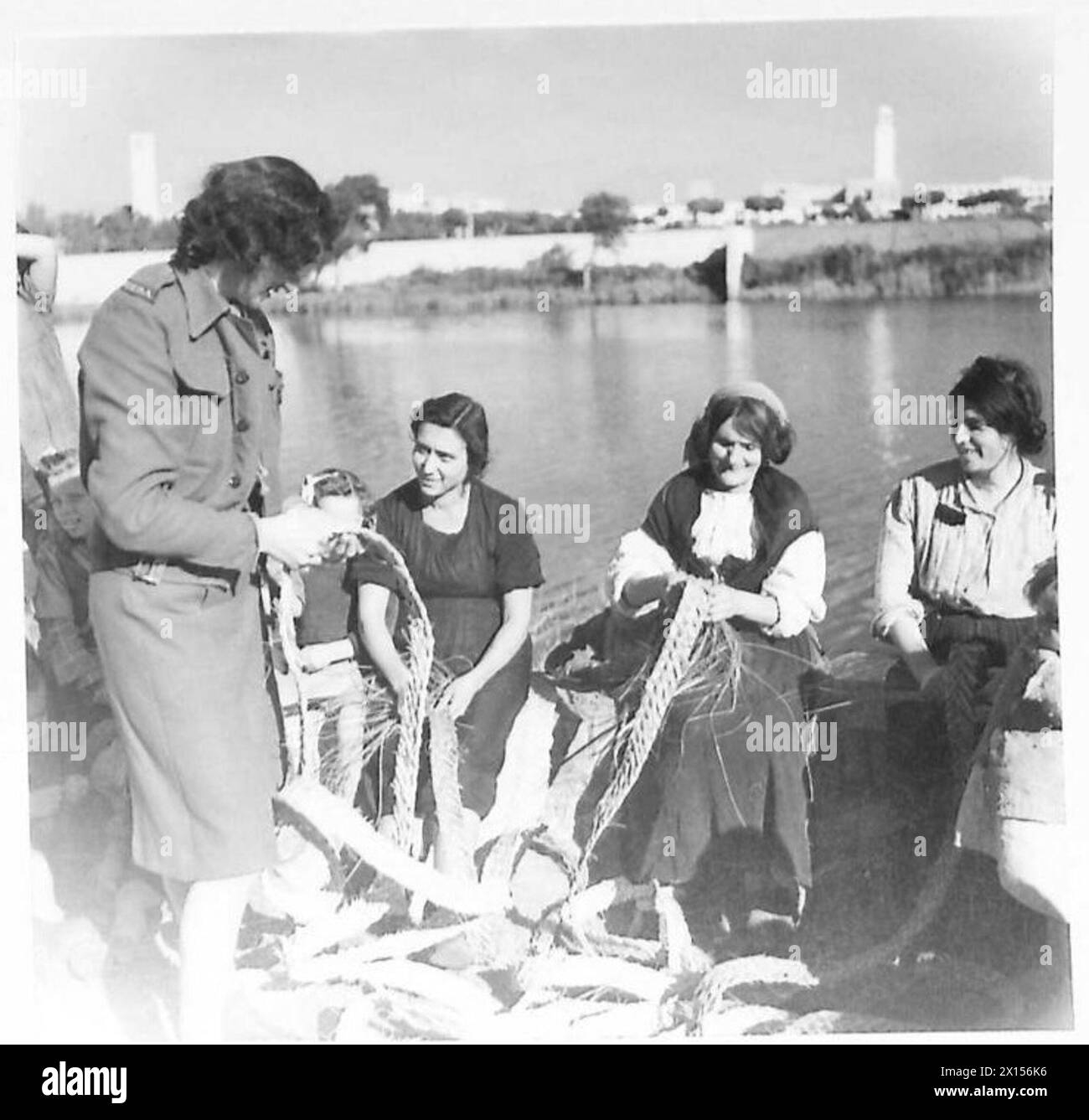 Frau Marjorie Owen von der CCRA arbeitet mit Flüchtlingsfrauen in Sabaudia, Provinz Latina, Italien, und stellt Körbe, Matten, und Stuhlsitze aus getrockneten und geflochtenen Seeufern. Stockfoto