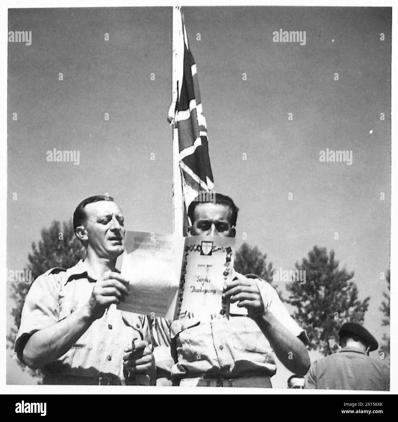 Zwei britische Soldaten folgen einem speziell gedruckten Programm während eines Thanksgiving Service der 8. Armee. Stockfoto