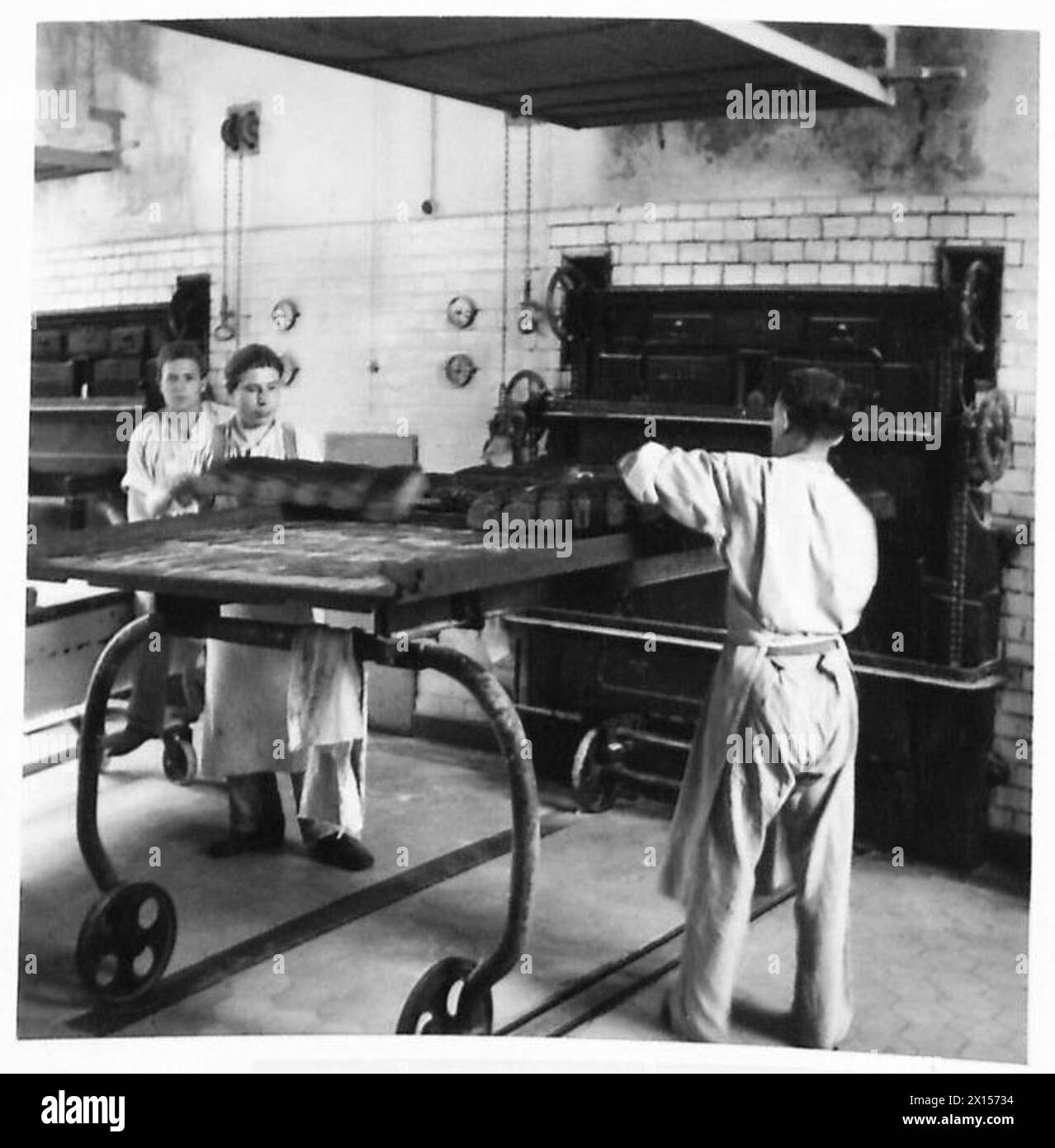 Bei der Wiederherstellung der Nahrungsmittelproduktion in einem Rheingebiet in Deutschland unter Aufsicht der britischen Armee, 21. Armeegruppe, wird Brot aus den Öfen entfernt. Stockfoto
