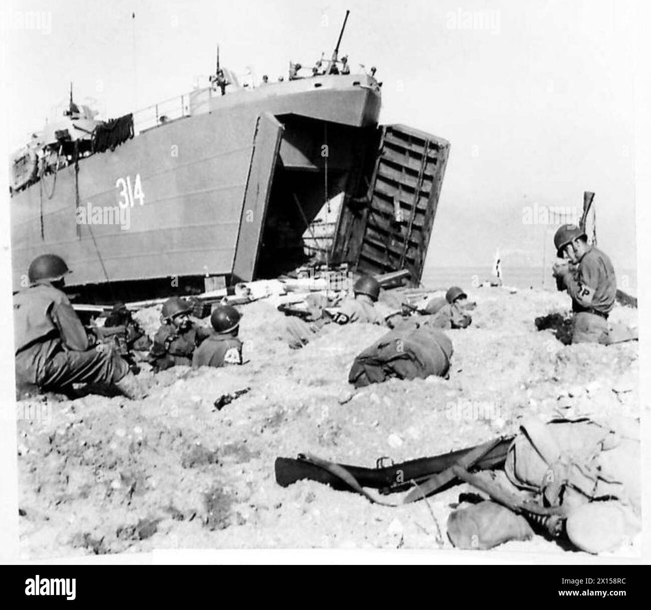 ITALIEN: FÜNFTE ARMEE LANDET IN SALERNO BAY, SÜDLICH VON NEAPEL - eine amerikanische Signalabteilung arbeitet in ihren Gräben am Strand im Hintergrund eine weitere L.S.T. bei der Entladung der britischen Armee Stockfoto