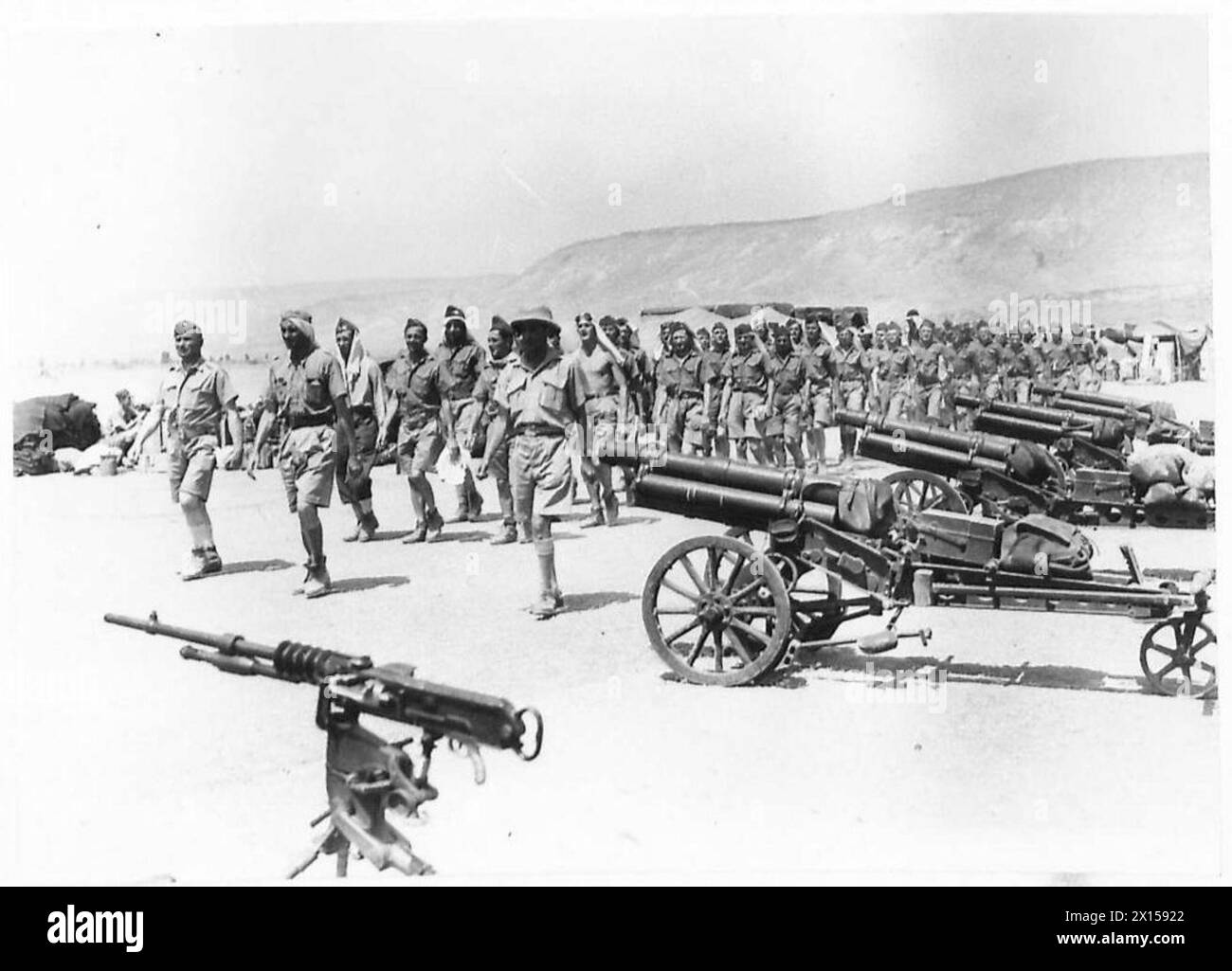 Soldaten der unabhängigen polnischen Karpaten-Brigade passieren französische 65 mm mle. 1906 Berggewehre und ein Maschinengewehr Hotchkiss M1914 auf einem Paradegelände in Samach, Palästina, 1940. Stockfoto
