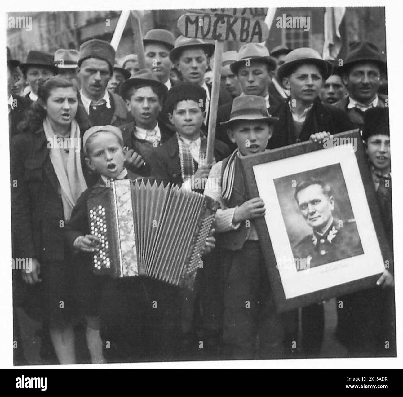 Die Menschenmassen in Jugoslawien feiern den 27. März und zeigen verschiedene Flaggen und Banner, darunter einen großen Union Jack, was die Beteiligung der Öffentlichkeit widerspiegelt. Stockfoto