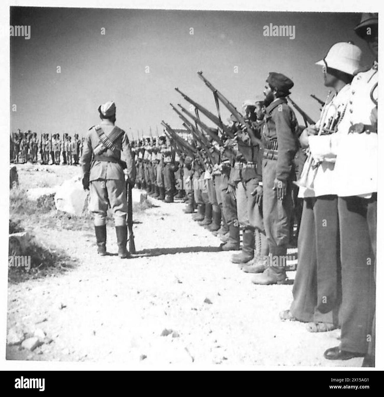 Foto, das griechische Partisanen zeigt, die während der Zeremonie des Hissens der griechischen Flagge über dem Parthenon eine Garde der Ehre bilden, was die Rückkehr der griechischen Regierung nach Athen markiert. Stockfoto Foto, das griechische Partisanen zeigt, die während der Zeremonie des Hissens der griechischen Flagge über dem Parthenon eine Garde der Ehre bilden, was die Rückkehr der griechischen Regierung nach Athen markiert. Stockfoto