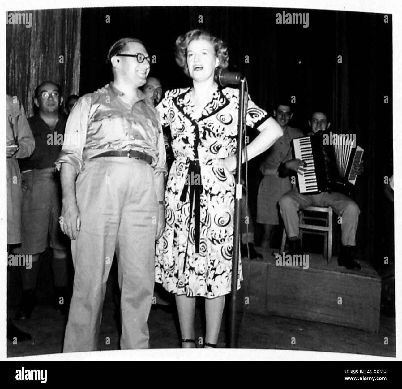 Gracie Fields spielt ein Duett mit dem Pianisten Teddie Holmes, begleitet vom Orchester „Stars in Battledress“. Stockfoto Gracie Fields spielt ein Duett mit dem Pianisten Teddie Holmes, begleitet vom Orchester „Stars in Battledress“. Stockfoto