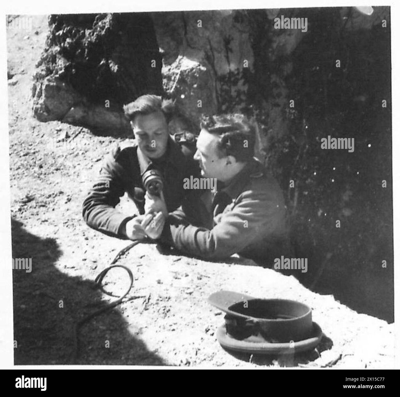 5. ARMEE - Korrespondent R. Beckwith von B.C. spricht mit Sgt. J. Jessiman, A.F.P.U. am Eingang zu einer Höhle an der Cassino-Front. Sgt. Jessiman berichtet aus Augenzeugen über die Zerstörung der L.S.T., die deutsche Gefangene vom Anzio-Brückenkopf transportierte, und die am 28. März 1944 auf den Felsen der Insel Ponza an Land gefegt wurde Stockfoto
