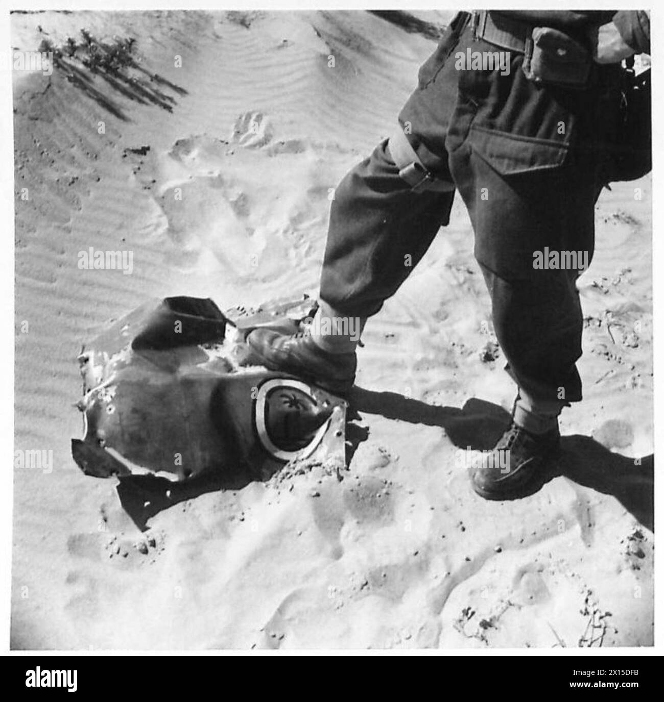 Britische First Army Truppen der britischen Armee erobern Kairouan. Ein Soldat steht auf deutschem Wrack in der Ebene außerhalb der Stadt, mit dem Schild des Afrika-Korps. Stockfoto