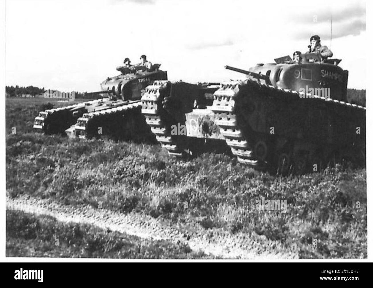 Churchill-Panzer bewegen sich während einer militärischen Übung durch unwegsames Gelände und zeigen gepanzerte Mobilität und Kampffeldmanövrierfähigkeiten. Stockfoto