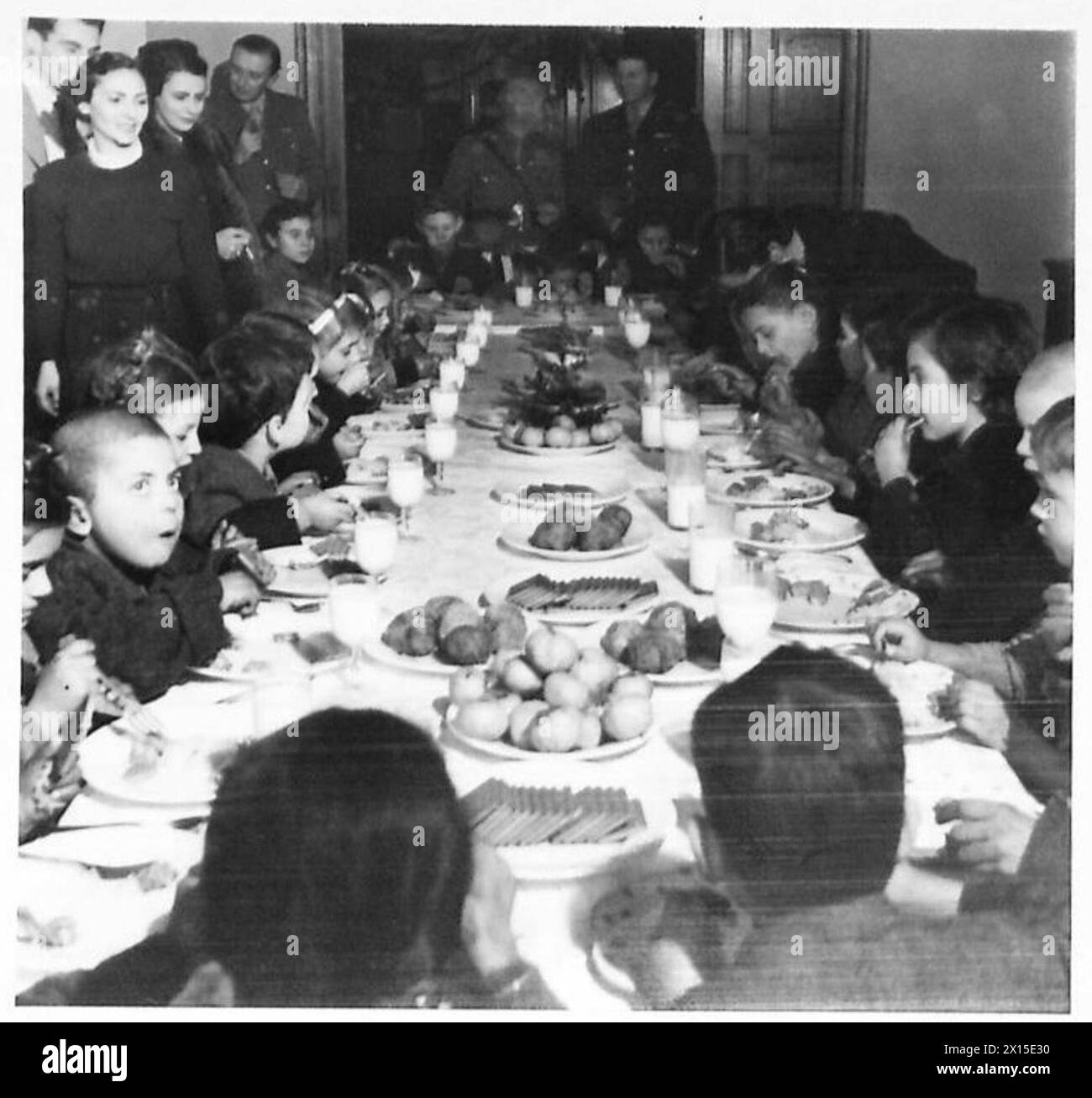 Griechische Kinder genießen eine herzhafte Mahlzeit während einer Silvesterparty, die von britischen Armeepersonal in Griechenland organisiert wird. Stockfoto