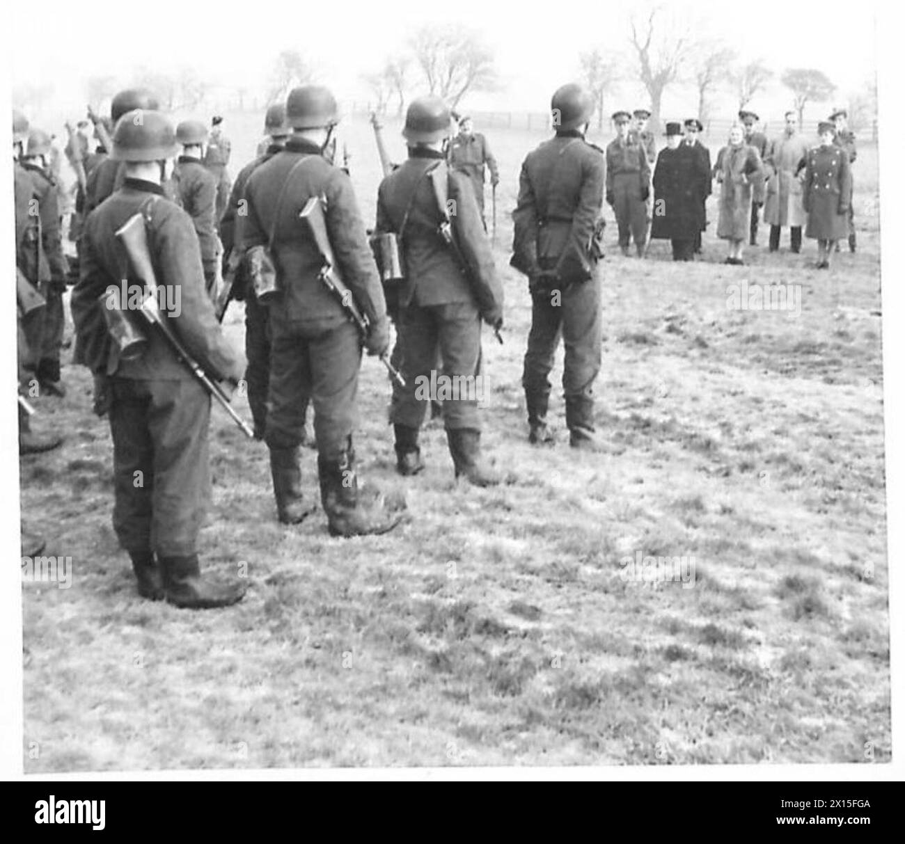 DER PREMIERMINISTER BEOBACHTET DIE NEUESTE INFANTERIE-AUSBILDUNG - Premierminister und Partei waren sehr an einem "deutschen" Demonstrationszug interessiert. Diese Schüler der Schule tragen deutsche Uniformen, Waffen und Ausrüstung und demonstrieren deutsche Infanterietechnik und Formationen der Britischen Armee Stockfoto