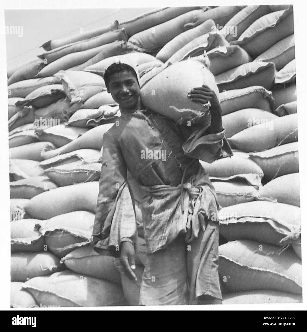 NAHRUNGSMITTELVORRÄTE FÜR DEN NAHEN OSTEN - ein ägyptischer Arbeiter an den Docks lächelt glücklich über die Aussicht, dass Weizen für ihn und seine Landsleute reichlicher sein könnte Stockfoto