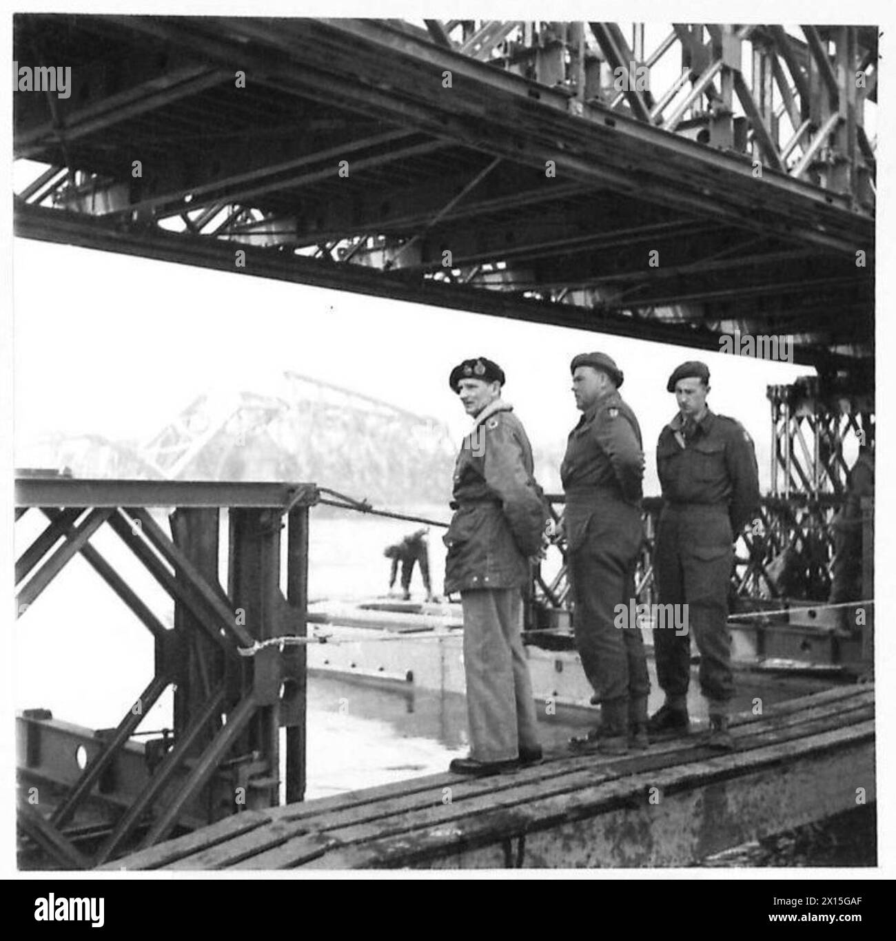 FELDMARSCHALL MONTGOMERY BEOBACHTET, WIE DER RHEIN DIE PROBE ÜBERQUERT – auf dem Weg zur Übung hielt der C-in-C an, um zu beobachten, wie die RES eine Bailey-Brücke über die Maas bei Venlo baute. Die Überreste der alten Brücke sind im Hintergrund der British Army, 21st Army Group zu sehen Stockfoto
