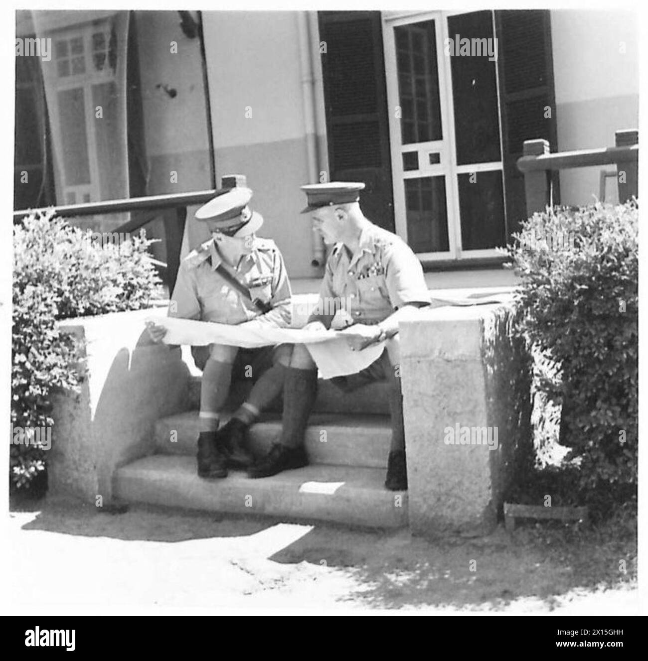 Zwei Kriegschefs führen während eines Treffens eine Konsultation über eine Karte durch, in der sie die Militärplanung unter der Britischen Armee erörtern. Stockfoto