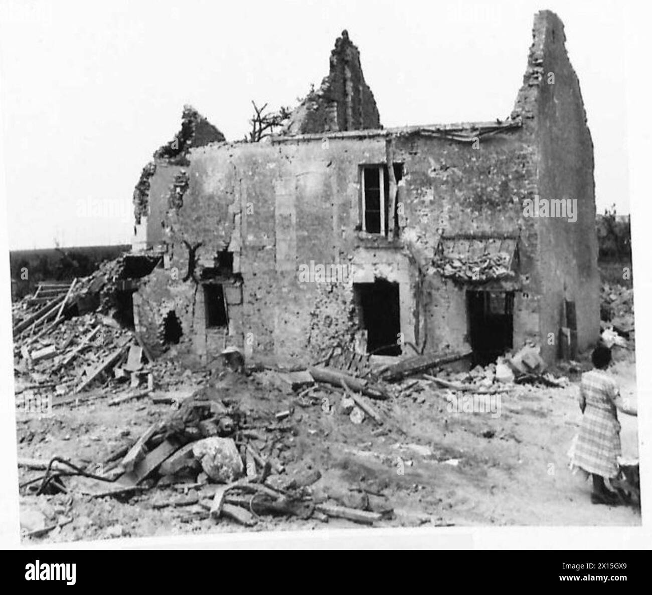 Eine französische Familie inspiziert beschädigte Häuser in ihrem Dorf, die durch Beschuss zerstört wurden, unter der Aufsicht der britischen Armee, 21. Armeegruppe. Stockfoto