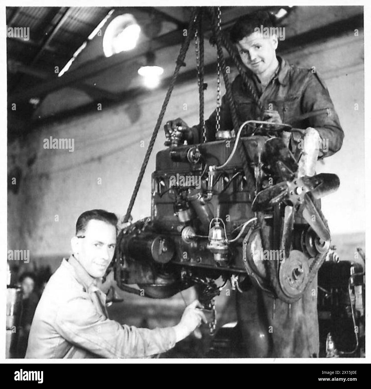 Corporal C.W. Pöttinger und Corporal E.D.C. Chaplin überholen einen LKW-Motor in einer Werkstatt in Italien. Stockfoto
