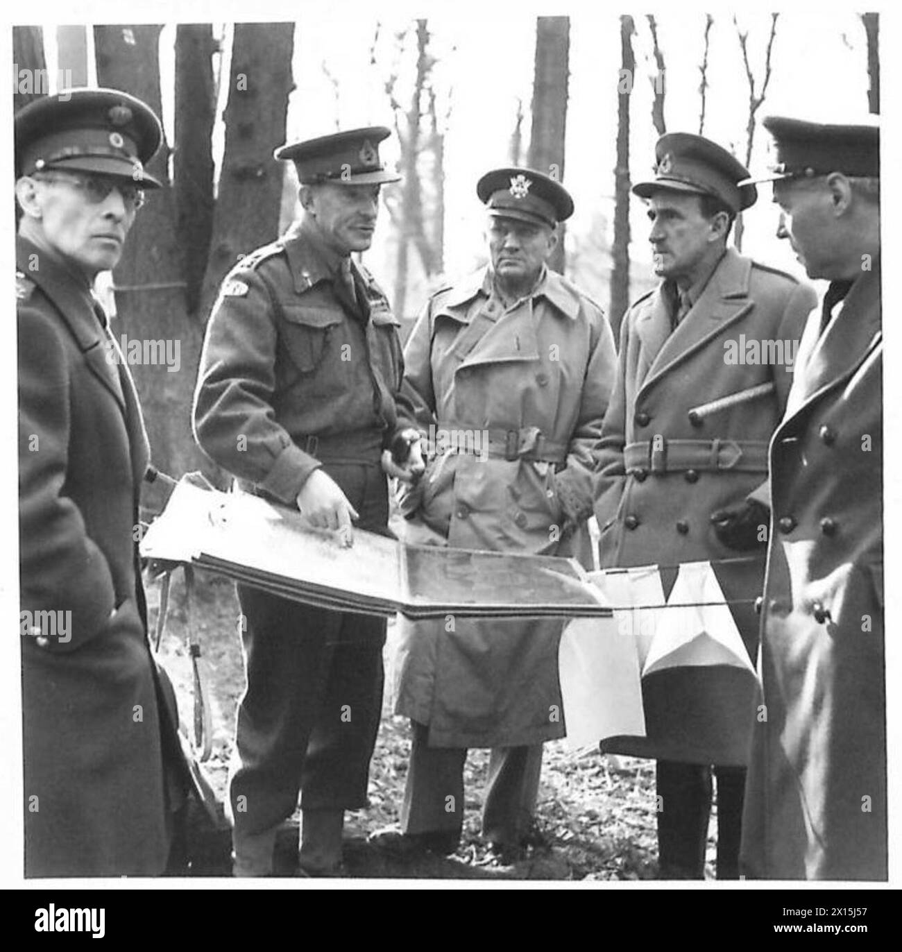 SPARTAN-ÜBUNG - das C in C (2. Rechts) mit zwei interessierten Zuschauern, General Andrews, General Commanding US-Truppen im European Theatre of Operations (Mitte) und der König von Griechenland (links), die Details über Fortschritte und neue Schritte eines Generals im Feld der britischen Armee hören Stockfoto