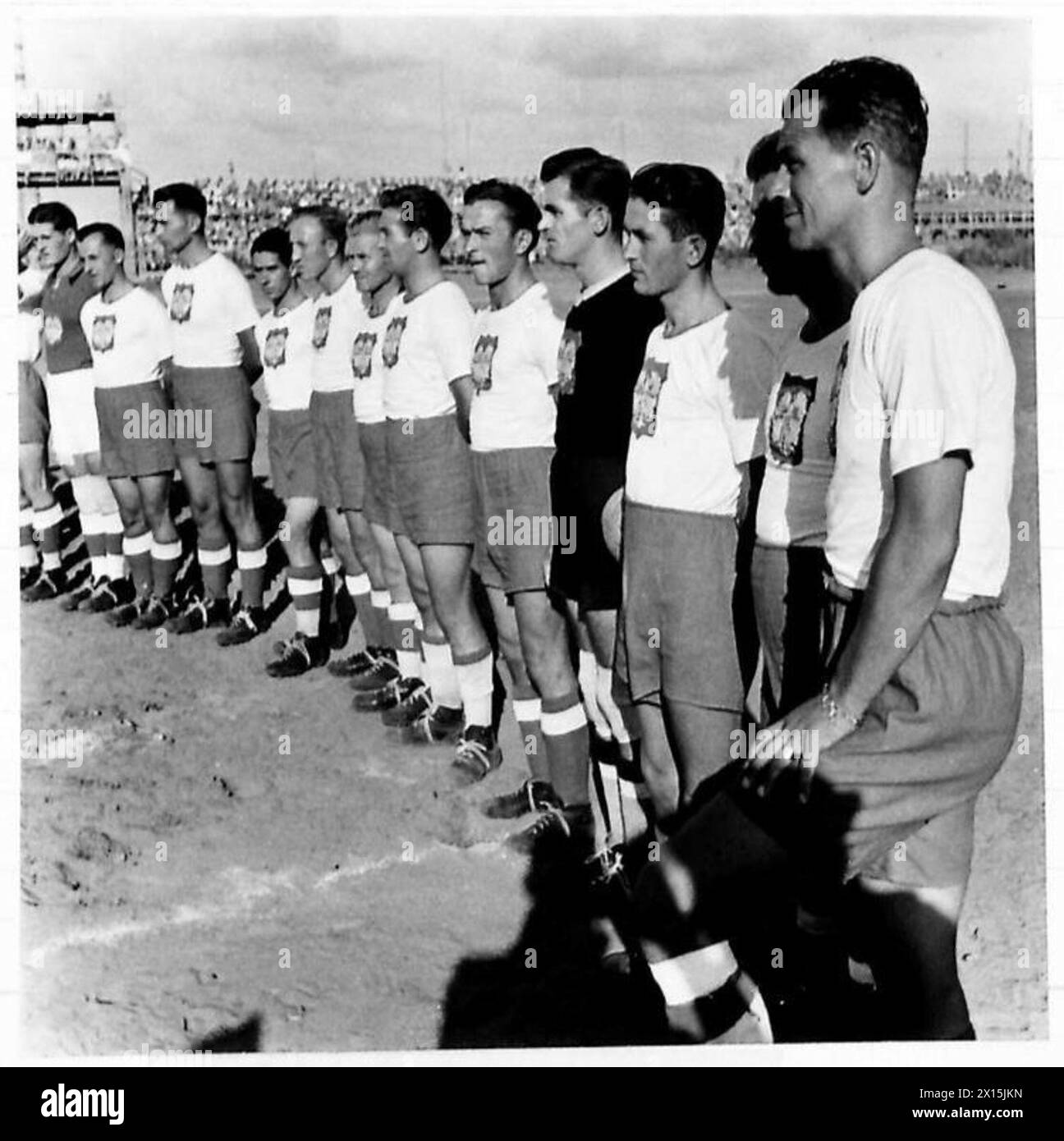 DIE POLNISCHE ARMEE IM NAHEN OSTEN, 1942-1943 – die polnische Fußballmannschaft trägt polnisches Wappen - Weißer Adler auf rotem Hintergrund - auf ihren Trikots. Im Stadion Tel Aviv fand ein Freundschaftsspiel zwischen der polnischen Armee im Nahen Osten und ganz Palästina statt, vertreten durch die Maccabi A-Mannschaft. Es kam zu einer enormen Menge von Zivilisten und Militärs; es war ein ausgezeichnetes Spiel zwischen gut aufeinander abgestimmten Teams und das Endergebnis war jeweils ein Tor. Fotos zeigen dieses Fußballspiel, das gerade im Gange ist, britische Armee, polnische Armee, polnische Streitkräfte im Westen, polnische Armee in der Mitte Stockfoto