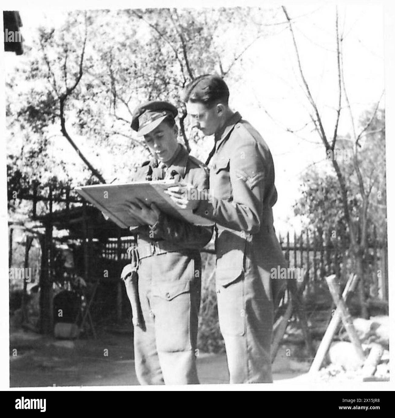 Lieutenant Power gibt Anweisungen an Vermessungsleiter Bdr. L. Worby nutzte eine Karte während einer Artillerieuntersuchung mit der Fünften Armee in Italien. Stockfoto