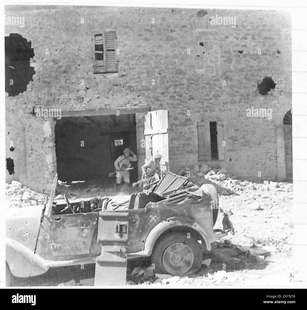 ACHTE ARMEE : GEFANGENNAHME VON TAVOLETO - die Patrouille arbeitet sich die Straße hinunter, vorbei an einem zerstörten deutschen Auto der britischen Armee Stockfoto