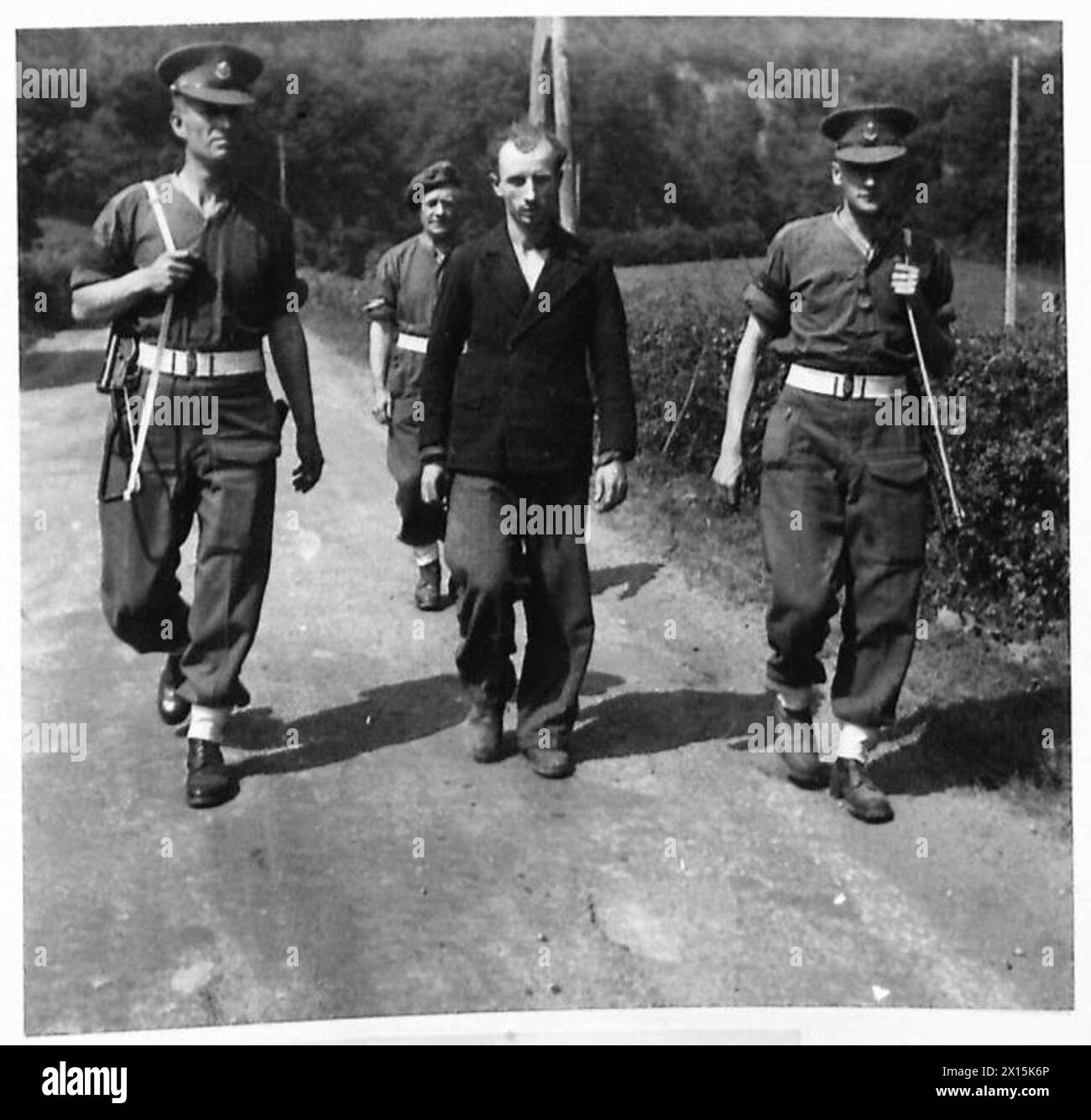 Ein deutscher Soldat in Zivilkleidung wird von der Feldsicherheitspolizei im hinteren Teil der Front des 8. Korps verhaftet, mit einer Rollfilmkamera mit zwei Rollen, britische Armee, 21. Armeegruppe. Stockfoto