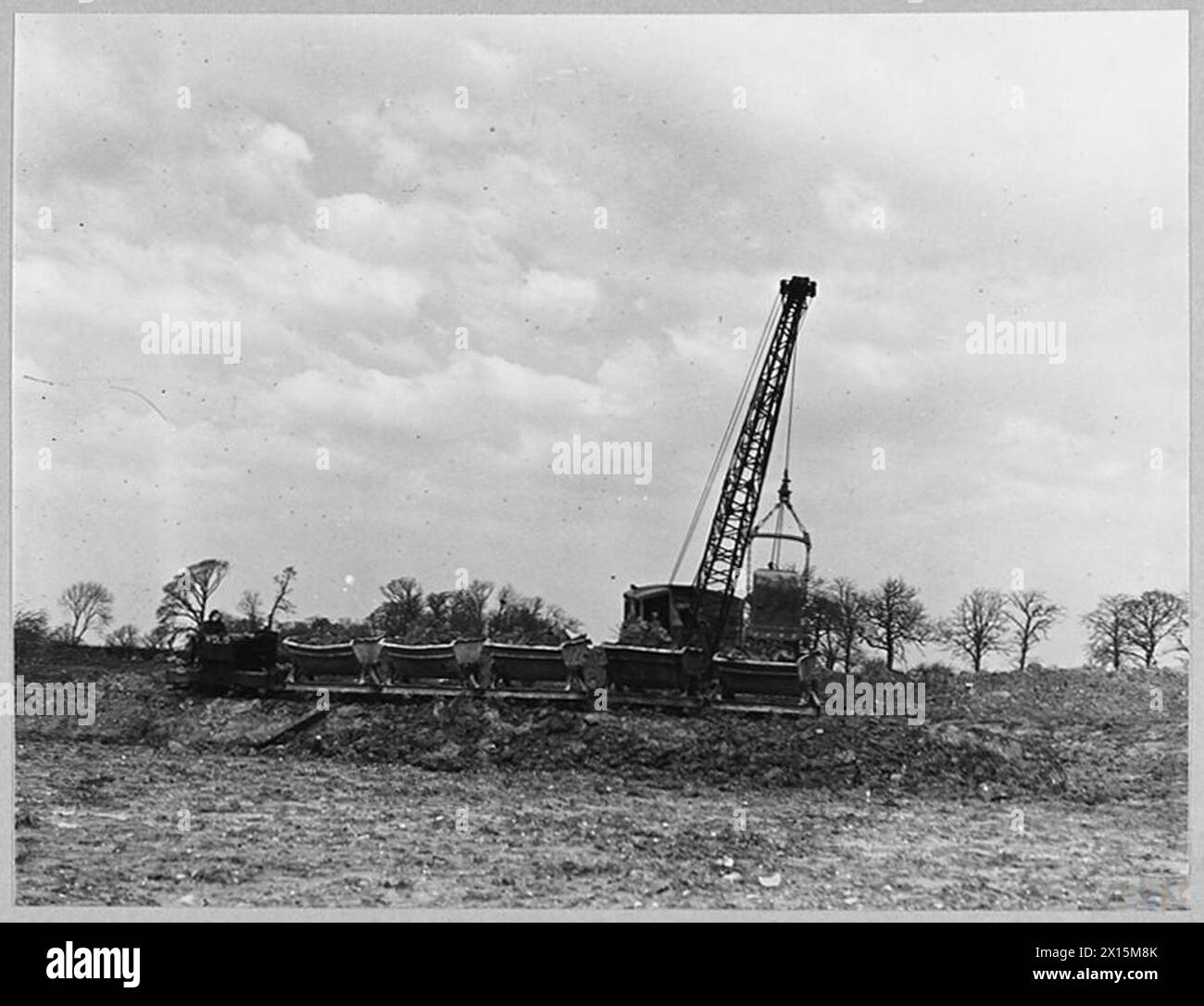 Ruston Bucyrus Bagger und zugehörige Ausrüstung werden verwendet, um einen Flugplatz in der Gegend um Midlands vorzubereiten, wobei 1943 Material in Jubilee Trucks geladen wird. Stockfoto