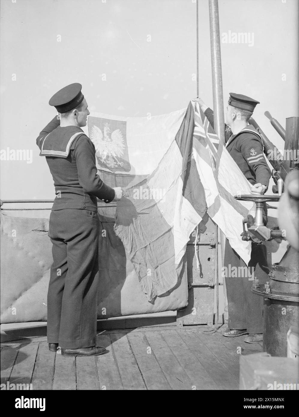Ein französisches Patrouillenschiff hisst drei Flaggen – britische, polnische und französische –, die auf die Anwesenheit französischer, polnischer und britischer Offiziere an Bord während der Marineoperationen hinweisen. Stockfoto