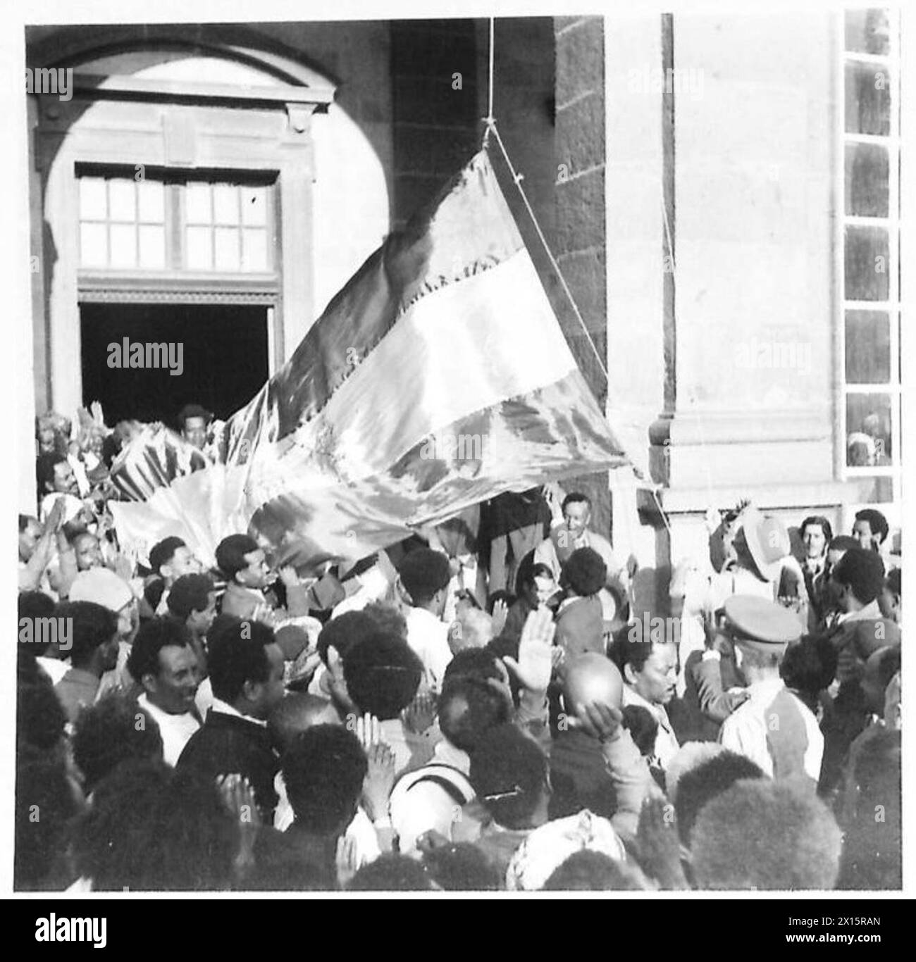 Britische Truppen in Addis Abeba werden von einem General beobachtet, der die Flagge des Löwen von Juda über dem Palast hisst. Stockfoto