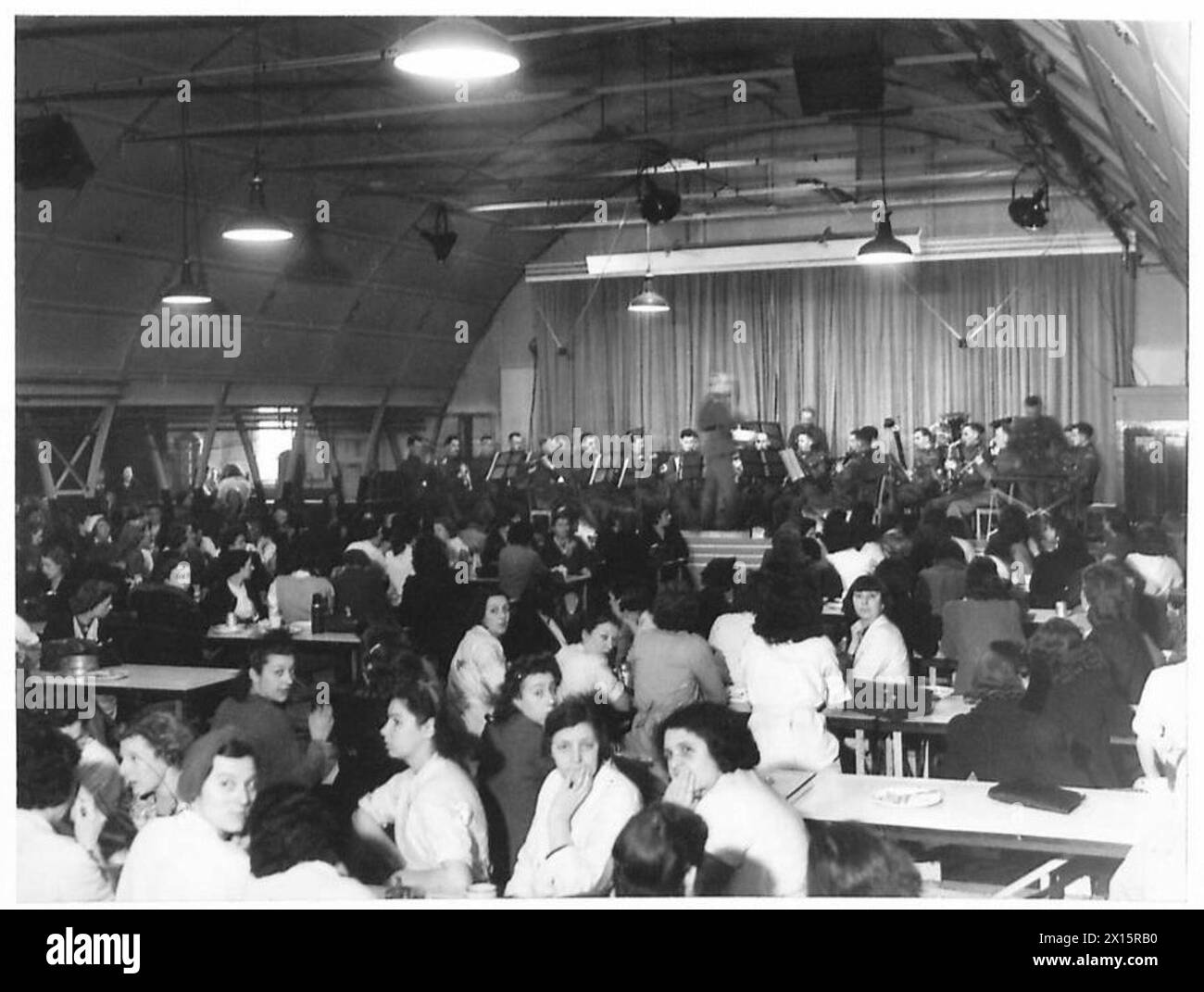 Die Gruppe der Grenadier-Garde tritt für Kriegsarbeiter in einer Kantine auf und zeigt, dass das Militär an Moral- und Unterhaltungsaktivitäten beteiligt ist. Stockfoto