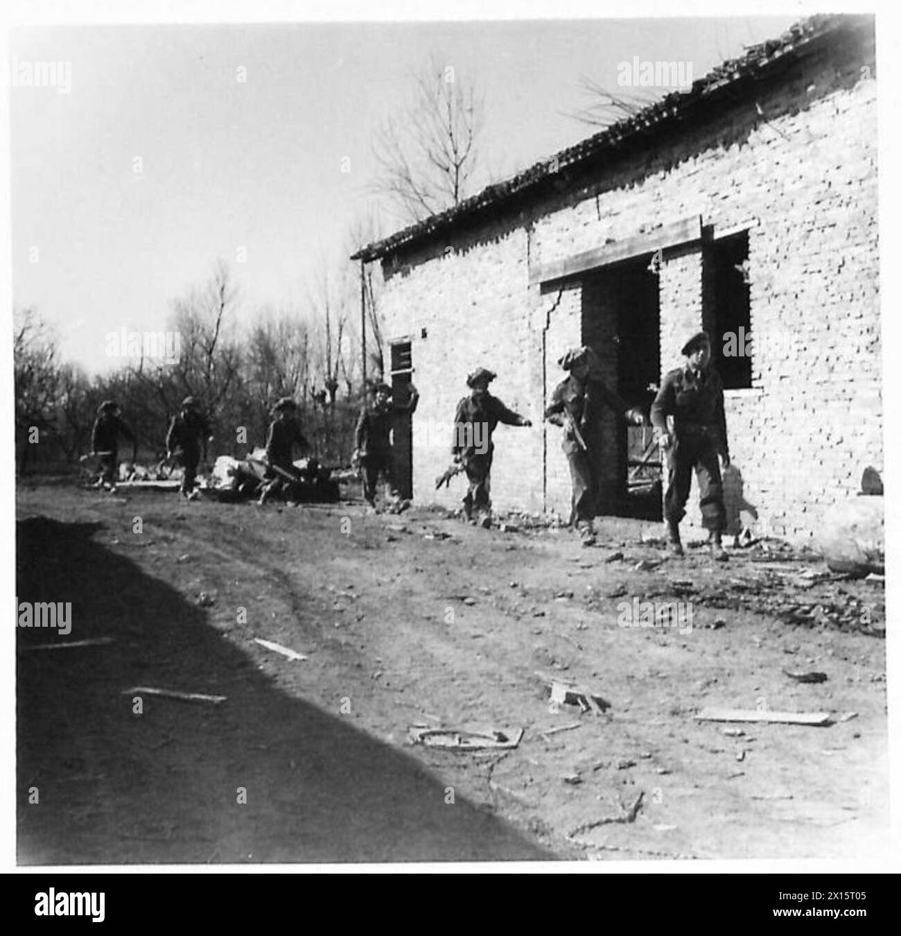 ACHTE ARMEE: JÜDISCHE BRIGADE IN AKTION – Eine Patrouille der Infanterie durchquert einen verlassenen Hof der britischen Armee Stockfoto