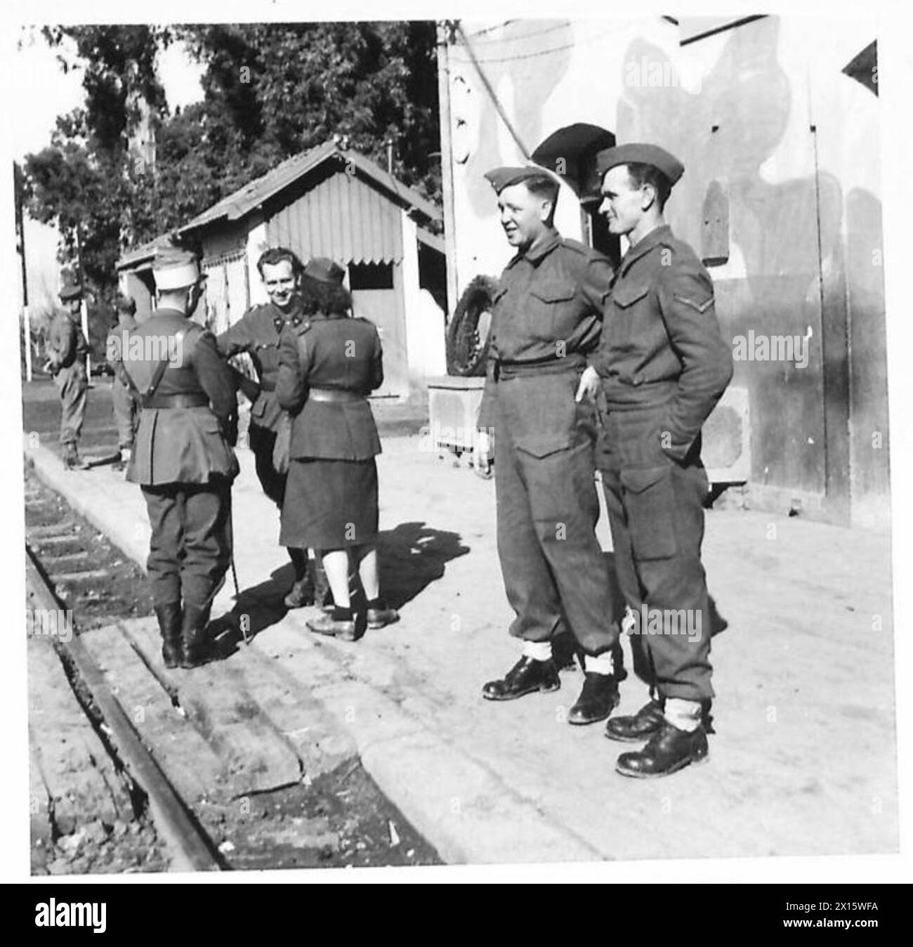 DIE BRITISCHE ARMEE IN NORDAFRIKA, SIZILIEN, ITALIEN, DEM BALKAN UND ÖSTERREICH 1942-1946 - Ein neuer Anblick für die Truppen im vorderen Bereich. Ein französisches ATS-Mädchen, das sich mit französischen Offizieren am Bahnhof Souk-el-Arba der Britischen Armee unterhält Stockfoto