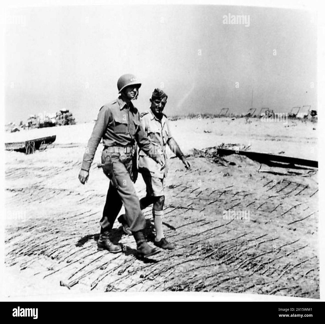 GENERAL ALEXANDER BESUCHT DIE SALERNO-FRONT - General Mark Clark und Air Marshal Coningham gehen entlang einer Strandstraße der britischen Armee Stockfoto