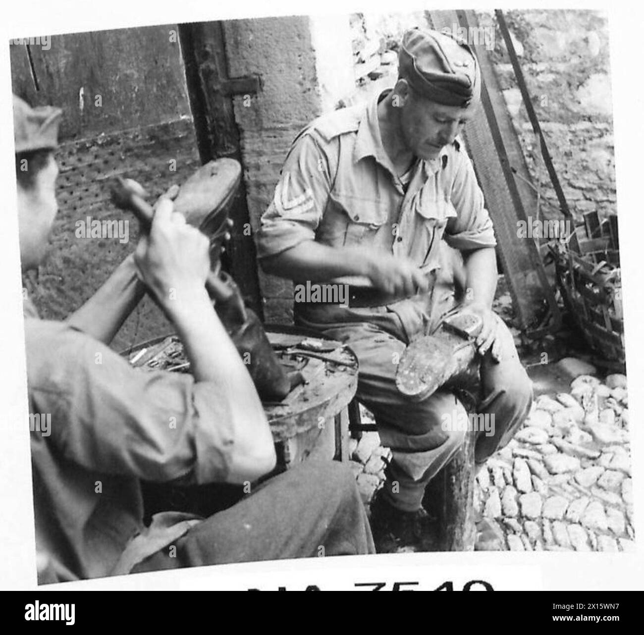Bombardier James Wright, Batteriekastenschuster aus Hanley, arbeitet mit dem Stadtschuster in Castilliccio dei Sauri nach der Entfernung der faschistischen Behörden zusammen. Stockfoto