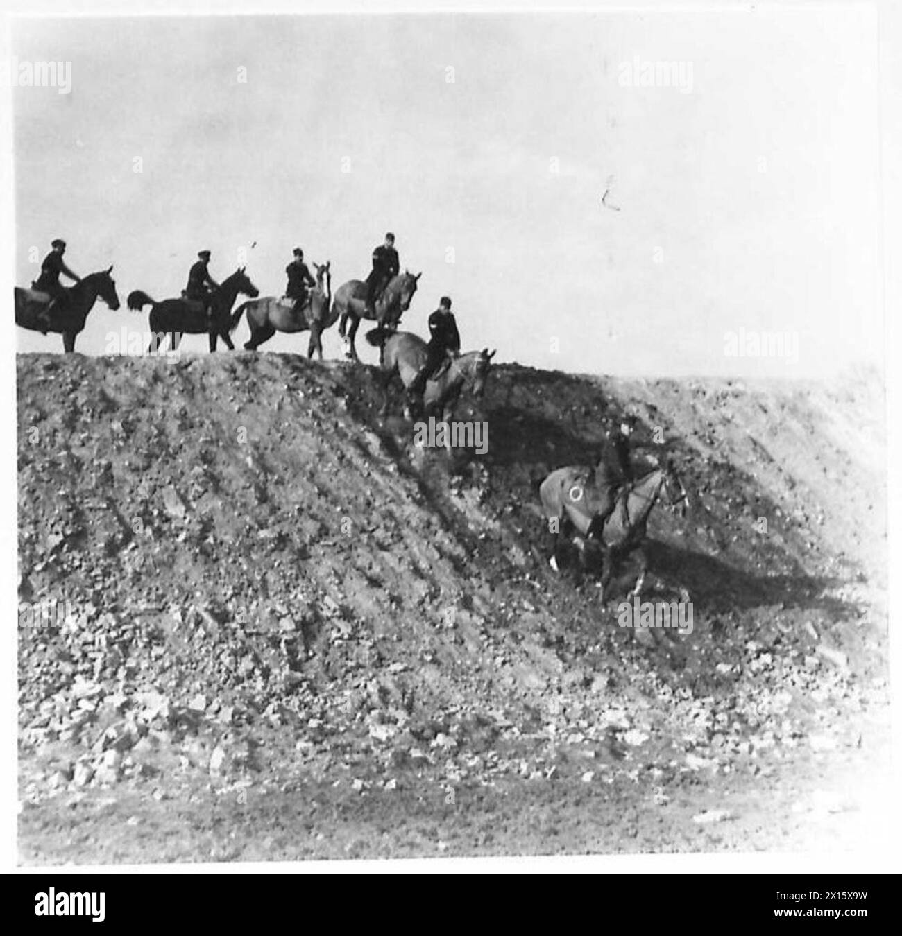 RSM Miller führt montierte Trainer an einem steilen Ufer entlang und demonstriert fortschrittliche Techniken zur Pferdekontrolle. Stockfoto