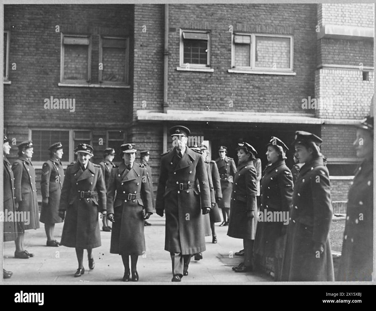 DUCHESS OF GLOUCESTER IM EMPFANGSZENTRUM DER FLUGBESATZUNG - 11980 Foto (ausgestellt 1944) zeigt - begleitet von Gruppenkapitäne A.H.H. Gilligan [Commanding Officer] und Flight Officer L.M. Ouseley, Air Chief Commandant The Duchess of Gloucester, inspiziert W.A.F. im Depot Royal Air Force Stockfoto