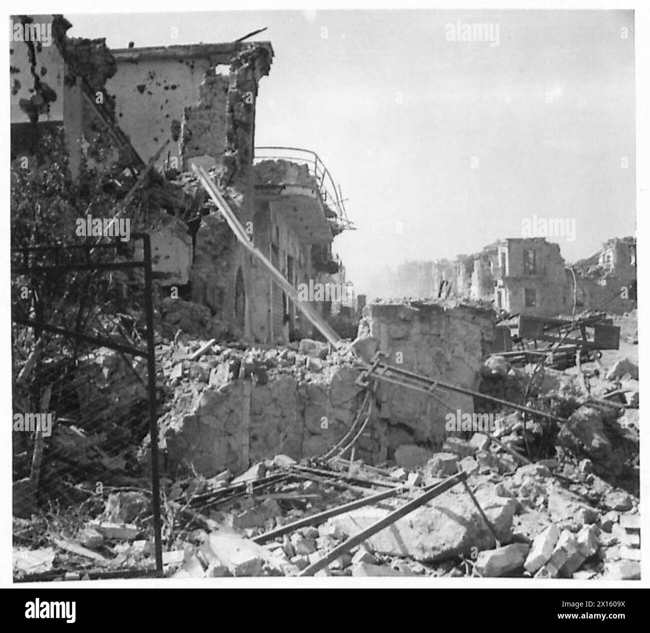 Ruinen von Gebäuden in Cisterna Di Littoria werden etwa 150 Meter entlang der Straße von Littoria gezeigt, die Schäden während militärischer Operationen dokumentieren. Stockfoto