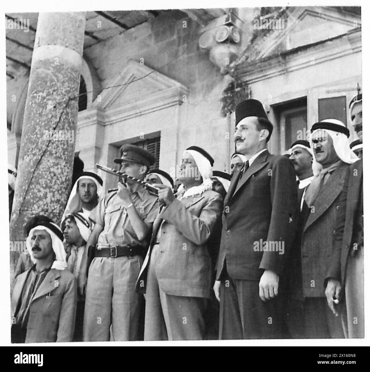 Britische Truppen dringen in Taibe, Syrien, vor, begrüßt von Scheite-Führer Ahmed el Assad Bey, wobei arabische Häuptlinge auf lokale Wahrzeichen hinweisen, die britische Armee. Stockfoto