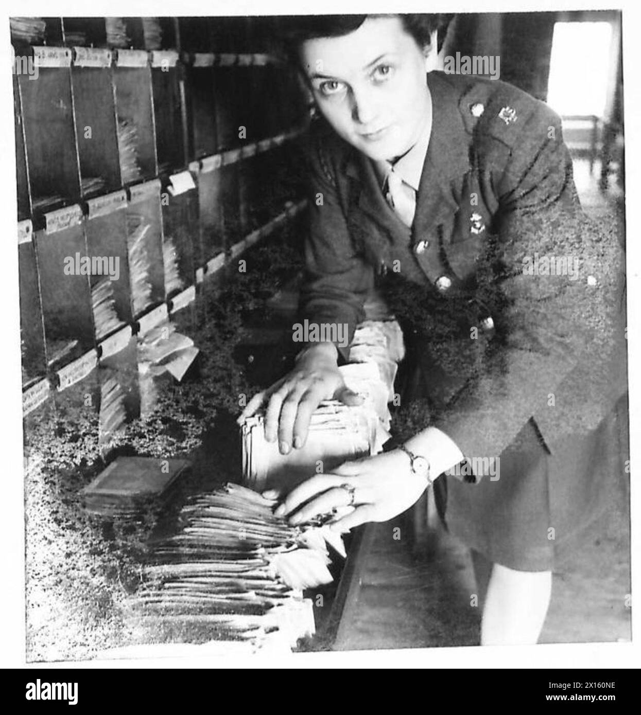 Mitglieder des Auxiliary Territory Service arbeiten in einem Postamt der British Army und bearbeiten Militärpost und -Korrespondenz. Stockfoto