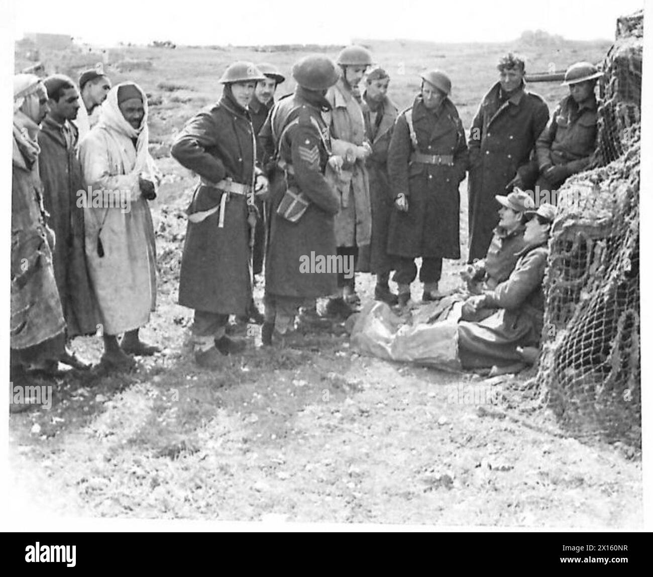 NACH DEM ERSTEN ARMEEANGRIFF AUF TOUKABEUR UND CHAOUACH in Chaouach werden zwei österreichische Gefangene von einer Field Secturity Sektion verhört, während Araber mit Interesse auf ihre verstorbenen Gäste schauen, die die britische Armee stören Stockfoto