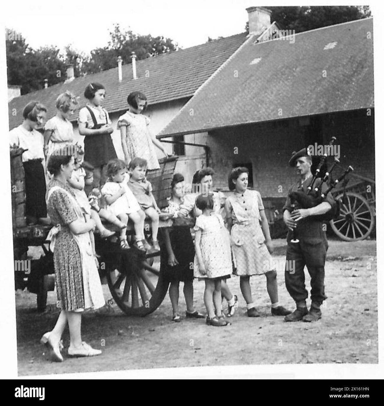 Pfeifenmajor John Massie aus Aberdeen unterhält Dorfbewohner in Ste. Croix Grande Tonne mit einem Auftritt auf seinem Dudelsack, der „Blue Bonnets Over the Border“, Royal Scots Fusiliers, British Army, 21st Army Group spielt. Stockfoto