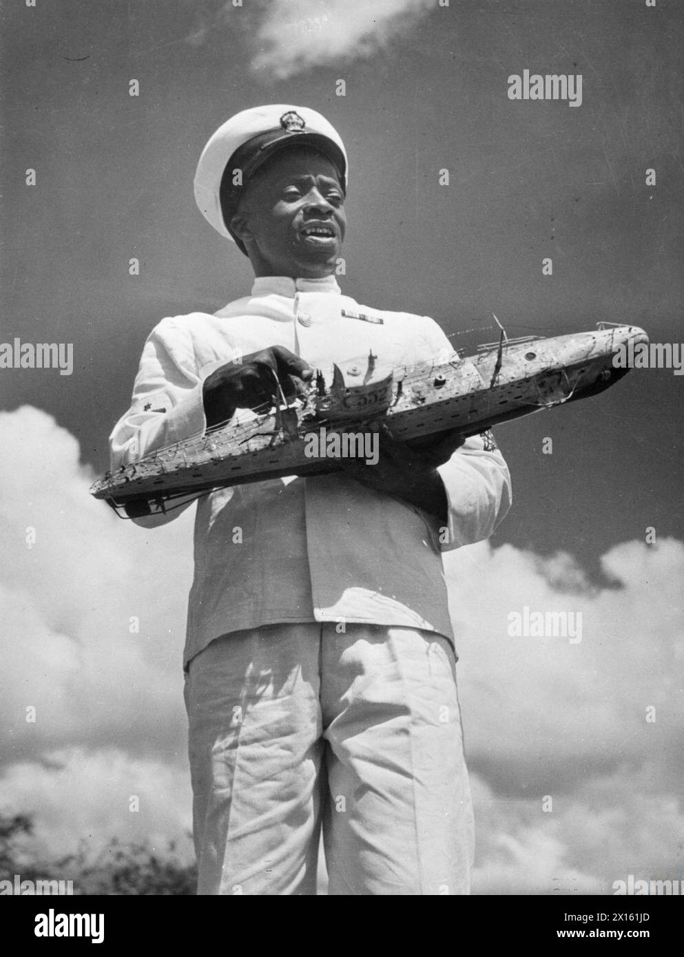 Petty Officer Ramazan Hassan vom Kenia Royal Naval Volunteer Reserve hält afrikanisches Publikum mit einem U-Boot-Modell. Er spricht sieben Sprachen und diente 24 Jahre in der Royal Navy. Stockfoto