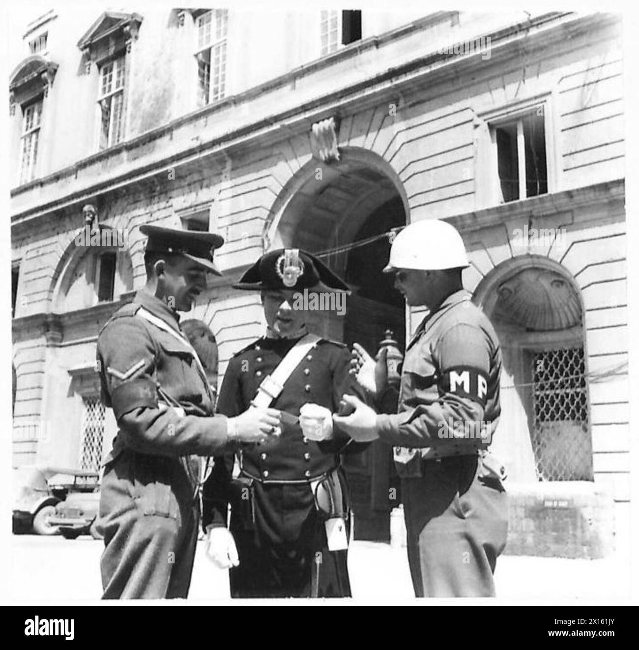 ITALIEN "VERBRÜDERUNG" - Internationale Polizei - britische Rote-Caps und amerikanische M.P. und italienische Carininieri - alle haben die Aufgaben der Polizei im Caserta-Palast. L/CPL. D.C. Milner aus Harrogate, Yorks, CPL. S.M. Wittner aus New York City und Bergamasco Liny aus Turin, Italien, sind im Innenhof der Palace British Army zu sehen Stockfoto