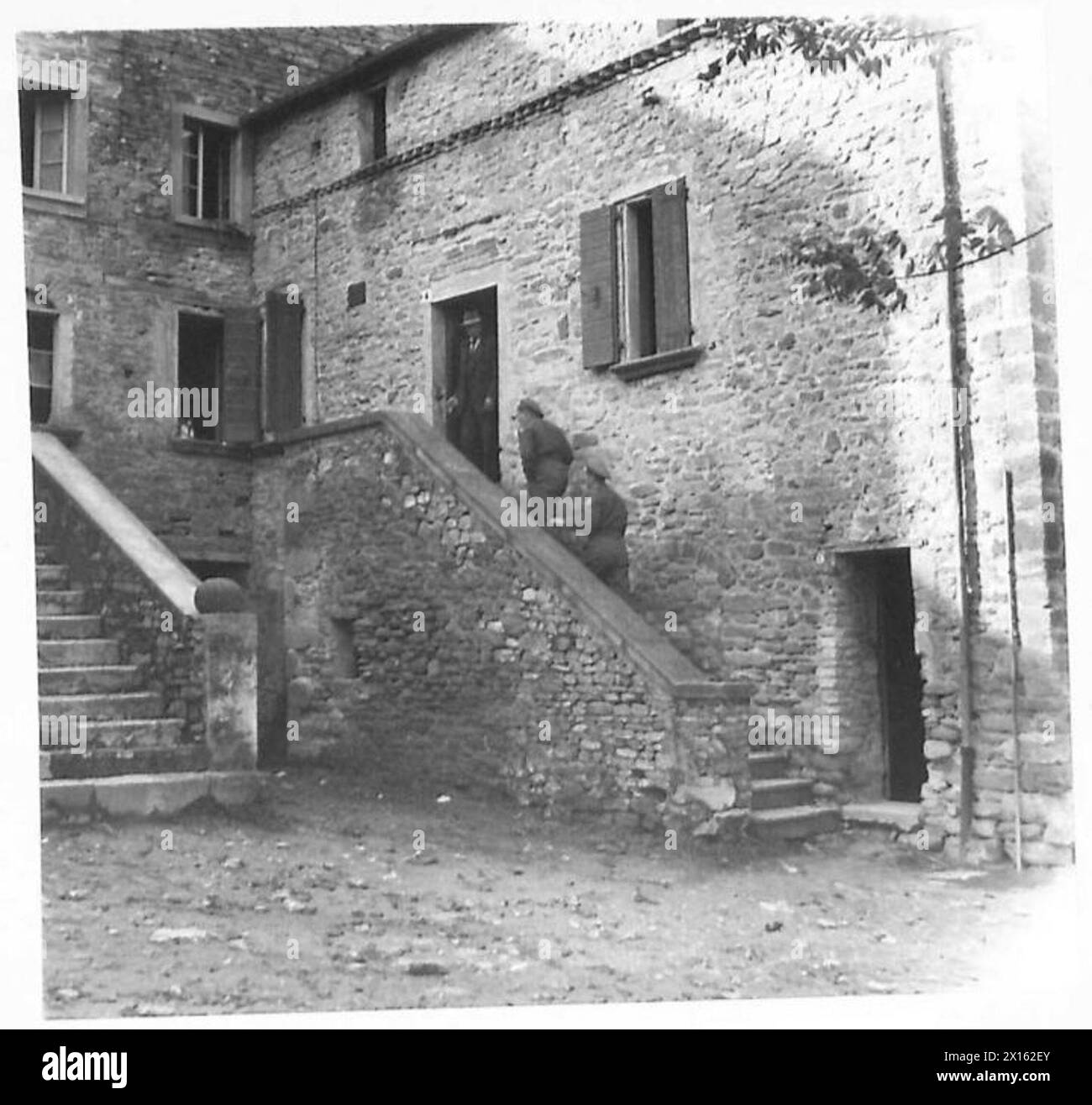 ITALIEN: ACHTE ARMEE: MUSSOLINIS GEBURTSORT UND BURG – polnische Soldaten gehen die Stufen hinauf, die zu dem Haus führen, in dem Mussolini geboren wurde Stockfoto