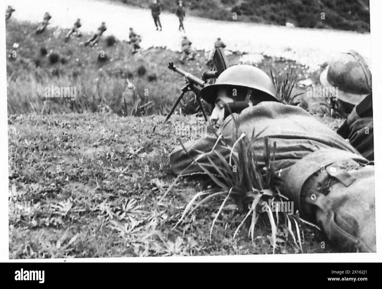 DIE ALLIIERTEN ARMEEN IM TUNESISCHEN FELDZUG, NOVEMBER 1942–MAI 1943 – Eine französische Sektion, die von einem britischen NCO mit seinem französischen Dolmetscher (auf der Straße) in der Verwendung von Deckung unterrichtet wird. In Nordafrika strömten zahlreiche Franzosen zu den Farben und meldeten sich freiwillig zum Militärdienst. Viele von ihnen haben in Frankreich gekämpft, einige waren sogar Kriegsgefangene, aber alle haben die totale Niederlage Deutschlands zum Ziel. Diese Rekruten tragen britische Uniformen und behalten als charakteristisches Kennzeichen die französische Casque und die Futtermütze. Auf der Kappe tragen sie einen roten, weißen und blauen Blitz für Großbritannien und Stockfoto