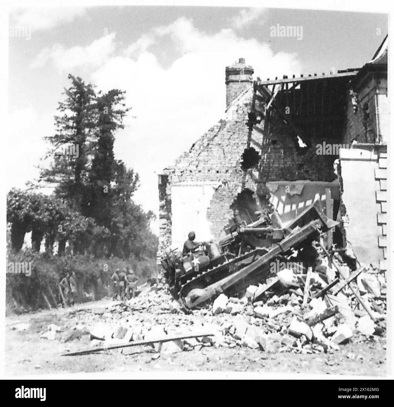 BULLDOZER BESEITIGEN HINDERNISSE - der Bulldozer stürzt in das Gebäude, um die Überreste der noch stehenden Mauern niederzuschlagen und die Trümmer von der britischen Armee, 21. Armeegruppe, zu entfernen Stockfoto