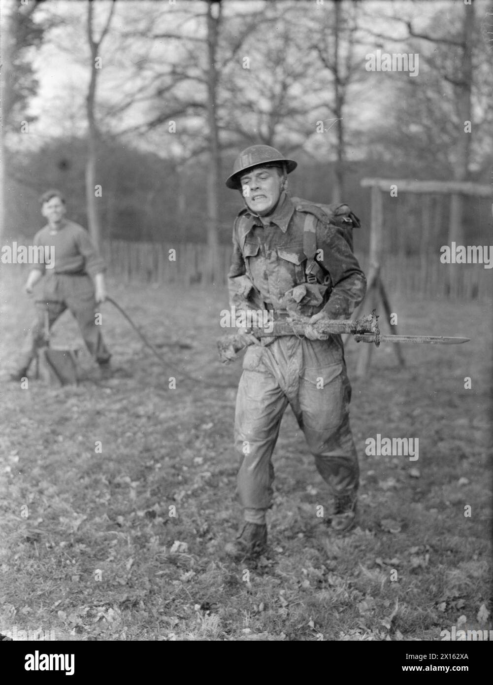 DIE BRITISCHE ARMEE IM VEREINIGTEN KÖNIGREICH 1939-45 – Erschöpfung und grimmige Entschlossenheit zeigen sich auf dem Gesicht eines Soldaten auf einem Angriffskurs an der Kampfschule der 44. Infanteriedivision im Dene Park bei Tonbridge in Kent, 8. April 1942 Stockfoto