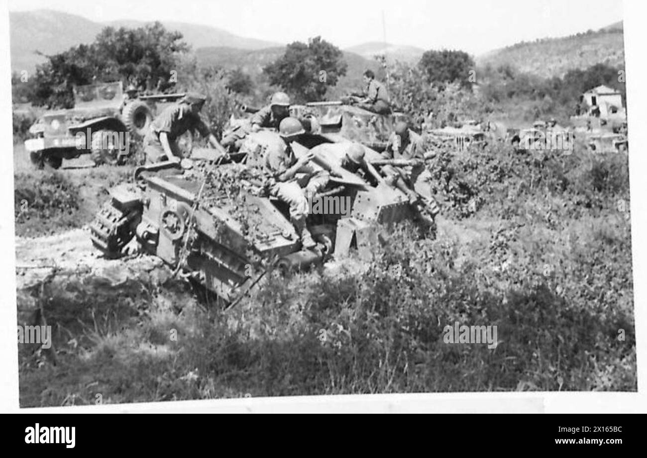Eine kaputte deutsche Selbstfahrwaffe und ein gepanzertes Auto sind auf der Straße bei Pico während der Feldzüge der britischen Armee in Nordafrika, Sizilien, Italien, auf dem Balkan und Österreich zu sehen. Stockfoto