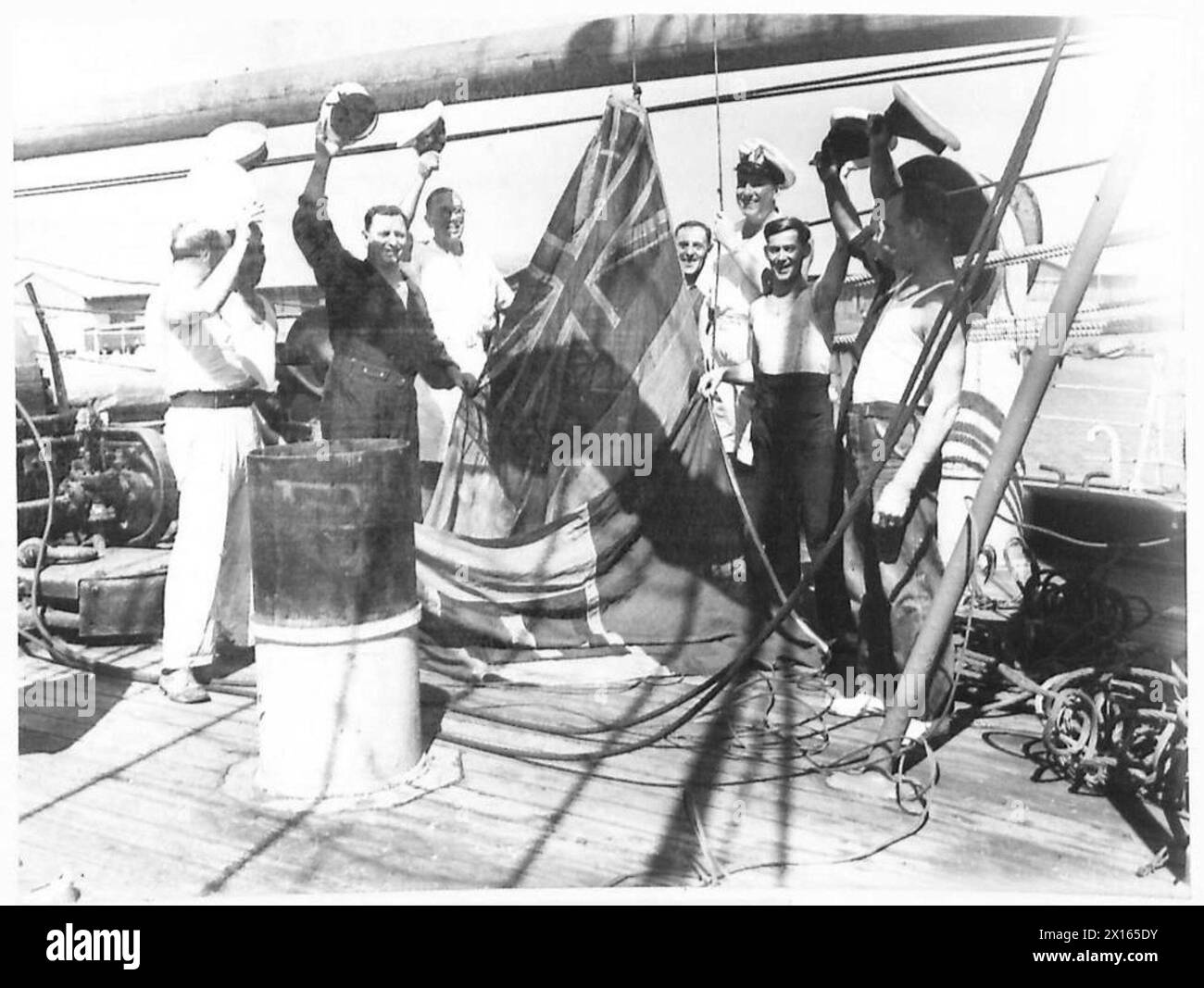 Ein italienisches Schiff wird während der Marineoperationen mit dem Roten Fähnrich über der italienischen Flagge gehoben. Stockfoto