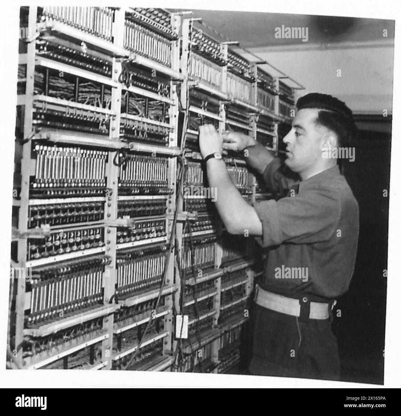 L/Corporal E. St. Quinton von 2nd Army Signals arbeitet an einem Hauptverteiler, wobei er seine technische Erfahrung vom Postamt unter der britischen Armee 21st Army Group einsetzt. Stockfoto