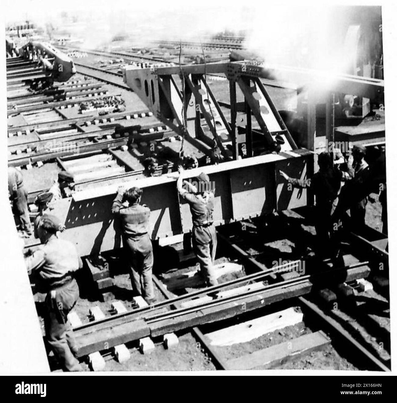 Die laufenden Arbeiten an den Querträgern einer Brücke zeigen TN. 5 Mitarbeiter, die beide Seiten verbinden und dabei technische und bauliche Aufgaben hervorheben. Stockfoto