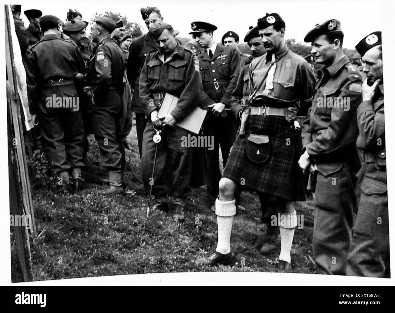 Britische Armeeoffiziere beobachten eine Demonstration deutscher Waffen und Taktiken und studieren Karten und Diagramme der Übung. Stockfoto